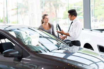 vehicle dealer showing young woman new car