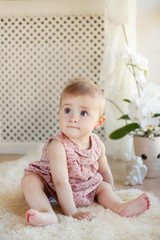 Fototapeta premium portrait of pretty smiling baby girl sitting on the floor