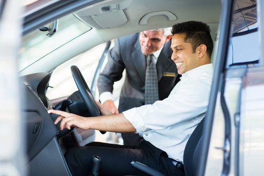 Indian Man Checking Car Features At Showroom