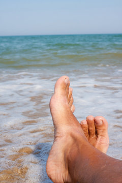 man's legs on the sand beach