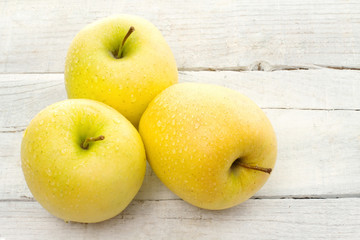 golden delicious apple over white wood