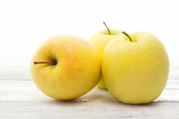 golden delicious apple over white wood