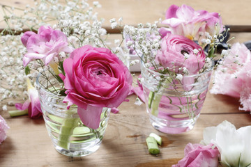 Florist workplace: incomplete tiny bouquets in glass vases. Step