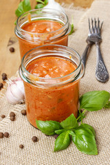 Two jars of tomato sauce (Bolognese sauce) on wooden table