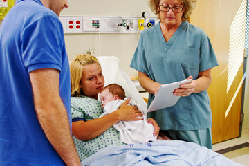 Nurse using tablet to give instructions to parents