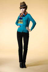 Full length young girl in fashion dress with hat in scarf posing