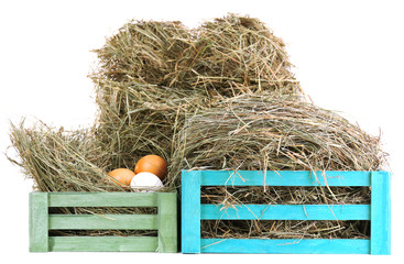 Hay in wooden crate with eggs, isolated on white