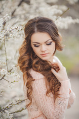 Portrait of a young brunette in the spring garden