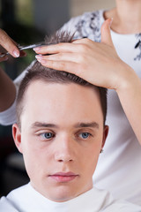 Hairdresser cutting man's hair