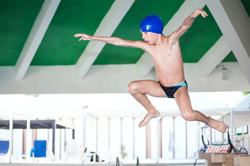 Beautiful child diving into a swimming pool. Frozen motion.