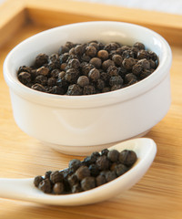 Black pepper on wood background