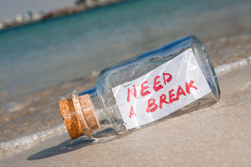 Vacation and stress concept. Bottle with message "need a break"