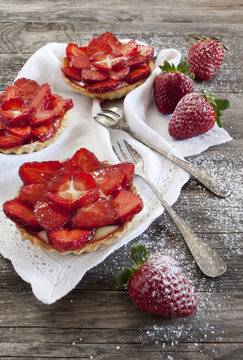 strawberries cakes on white napkin with forks on table