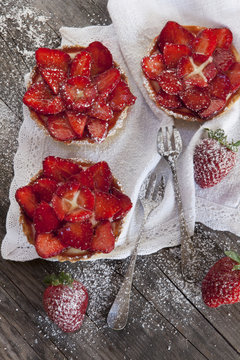 strawberries cakes on white napkin with little forks