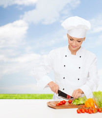 smiling female chef chopping vagetables