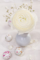 White ranunculus flower and chocolate easter candy