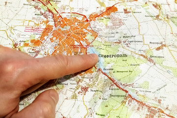 Fototapeta na wymiar The toe points to the city of Somferopol′ on the map of Crimea