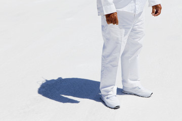 A man in white overalls, a race official timekeeper at a car racing event,  at Speed Week on Bonneville Salt Flats.