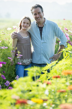 Summer on an organic farm. A man and a girl in a field of flowers.