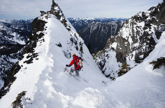 A skier ski-ing down The Slot snow slope on Snoqualmie Peak in the Cascades range, Washington state, USA.