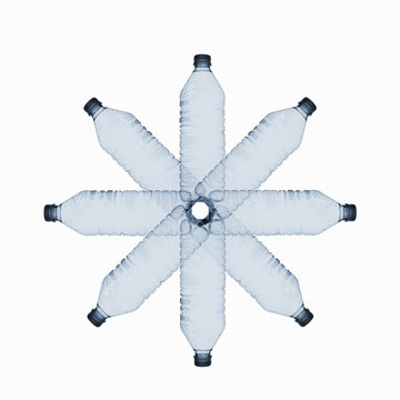 A small group of clear plastic bottles arranged in a circle, linked at the centre
