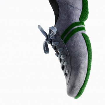 A single sneaker or trainer shoe with laces and green sole. 