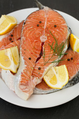 salmon on white plate on black background