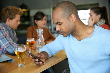 Man sitting at snack bar table checking messages