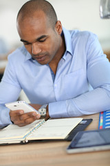 Young businessman recording meeting time in agenda