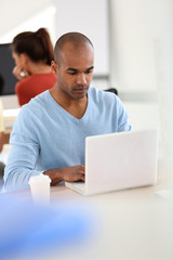 Young man in class working on laptop computer