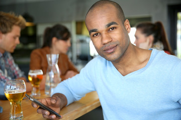Man sitting at snack bar table checking messages
