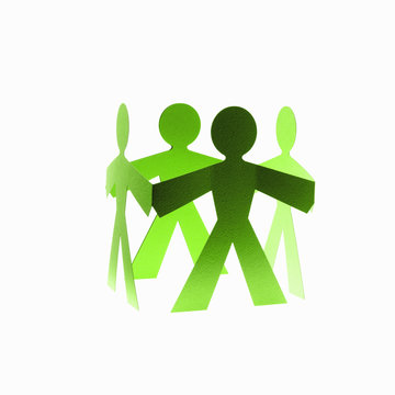 Papercuts, paper cut out figures representing people with joined hands. 