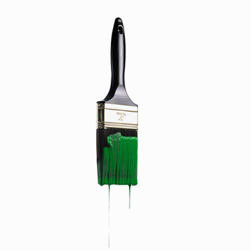A paintbrush loaded with green paint dripping off the bristles. 