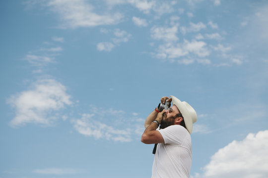 Man taking a photograph of clouds and sky.