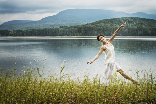 A Woman Dancing Gracefully In The Open Air Along The Lake Shore Near Woodstock, New York State, USA