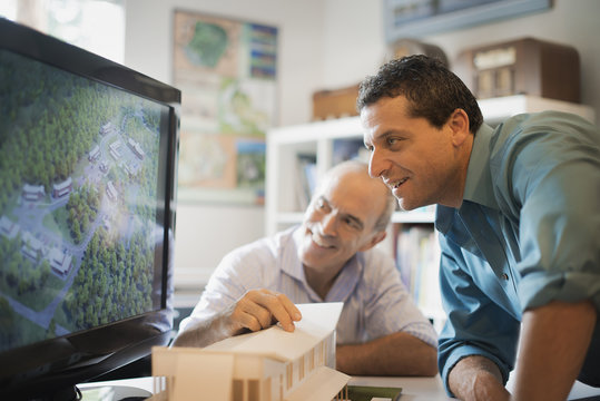 Two architects working on a green construction project, using computer technology. Scale model of a building. Computer design.