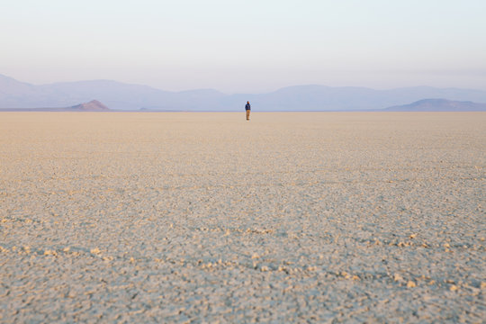 The figure of a man in the empty desert landscape of Black Rock desert, Nevada. 
