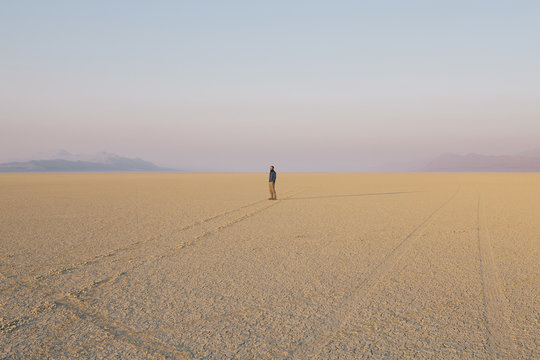 The figure of a man in the empty desert landscape of Black Rock desert, Nevada. 