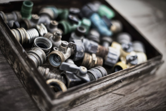 Washers and hose pipe joint fittings in a wooden box in the greenhouse. 