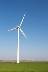 Fototapeta premium Windmill for wind energy in grass