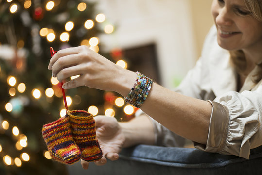 A young woman holding a pair of hand knitted baby booties.