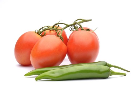 Bunch of fresh tomatoes and green pappers on white background