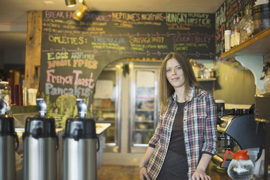 A coffee shop and cafe in High Falls called The Last Bite. A woman leaning on the counter, by the coffee machine.