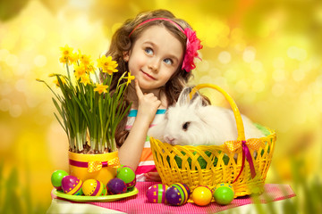 Happy little girl with easter rabbit and eggs