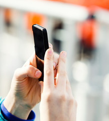 Woman using smart phone outdoor, close up photo
