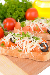 Delicious bruschetta with tomatoes on cutting board close-up