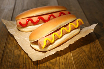 Tasty hot dogs on wooden table