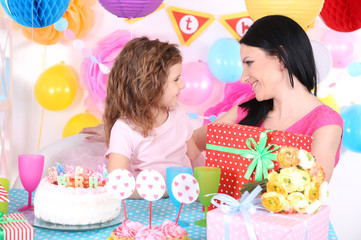 Pretty little girl with mom celebrate her birthday