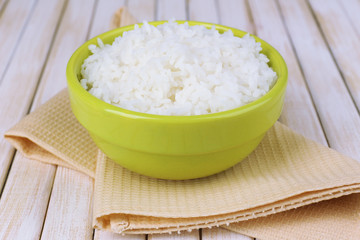 Cooked rice in bowl on wooden background