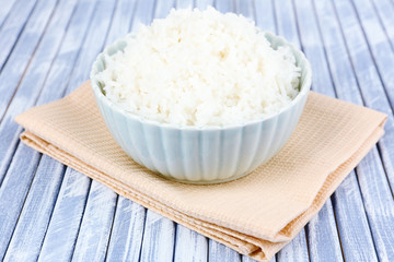 Cooked rice in bowl on wooden background